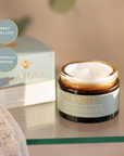 Maydi+ Renewal Day Cream jar with packaging on a glass surface