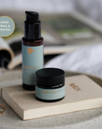 Two skincare products( brightening serum & Peptide Eye Cream) on a book with a blurred background