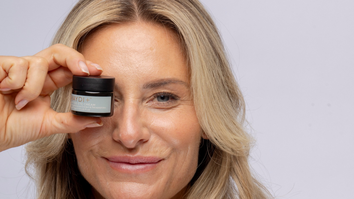 Blonde female holding Peptide Eye Cream